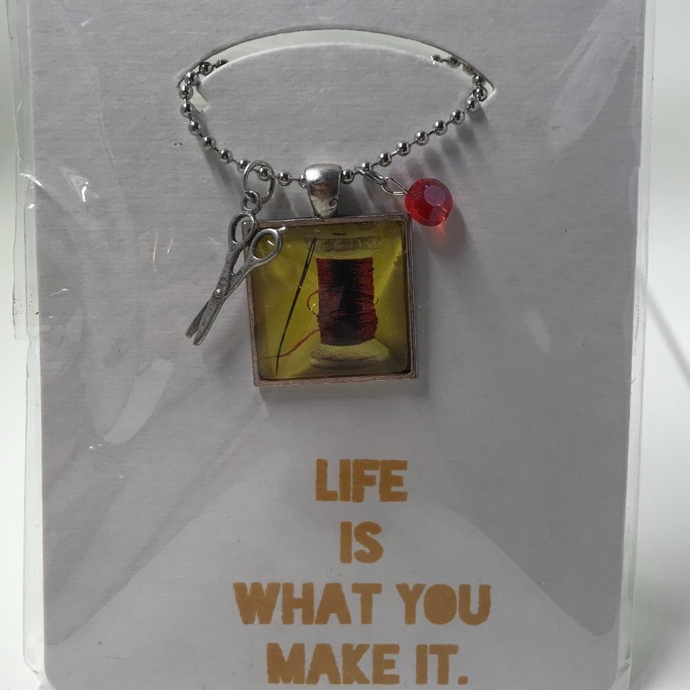 NEW Pendent necklace that has a needle and thread, 2 charms, & 22 inch chain